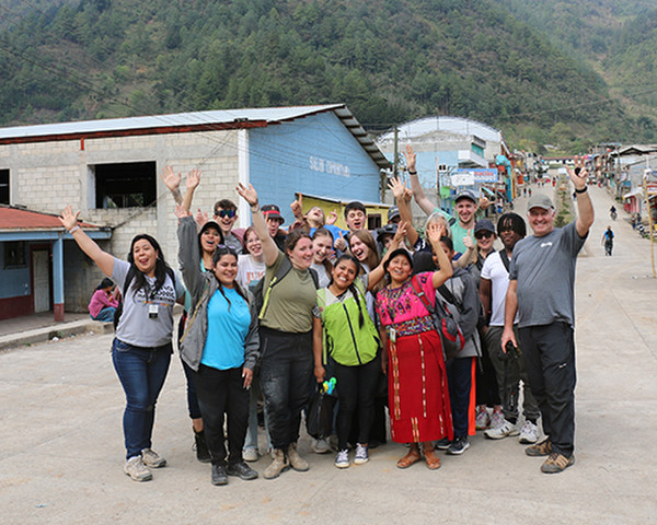 A group of Canadians from a church and Guatemalans stand and wave in a street in Acul, Guatemala