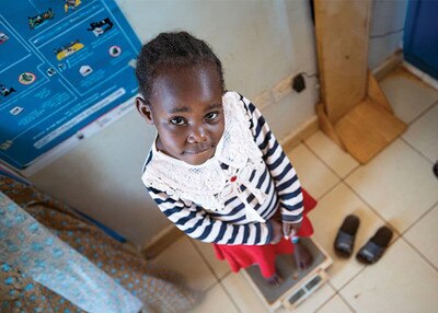 Little girl looking up as she is on top of a scale, check-up, doctor