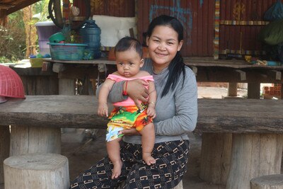 a smiling woman holding a baby in her arms, nutrition, breastfeed