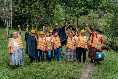 group of people with raised fist in the air, using high visibility vest and yellow hard hats