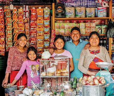 a happy family of five in front of their business