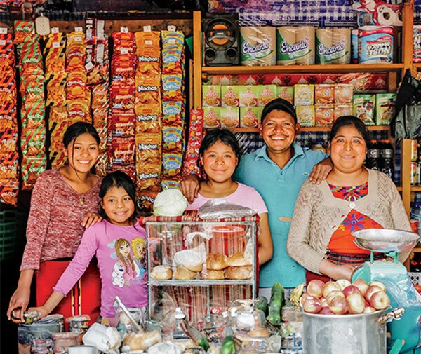 a happy family of five in front of their business