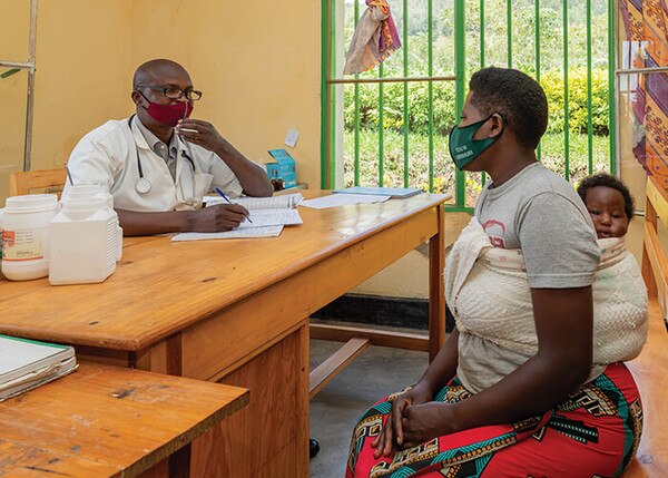 male doctor with a female patient that is carrying a baby 