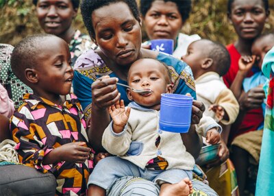 a smiling woman holding a baby in her arms, nutrition, breastfeed