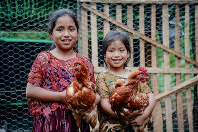 two happy girls holding chickens
