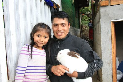 father and daughter holding a white rabbit