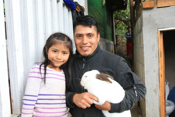 father and daughter holding a white rabbit