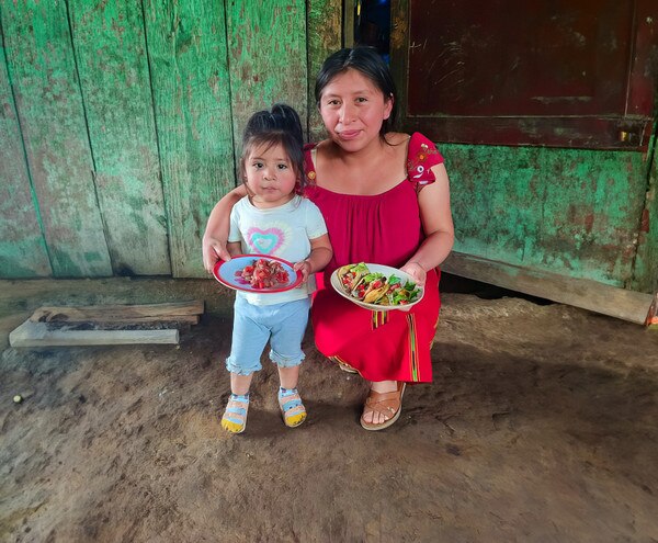 mother and daughter holding plates with food
