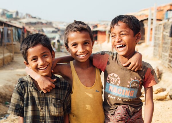 three smiling kids hugging